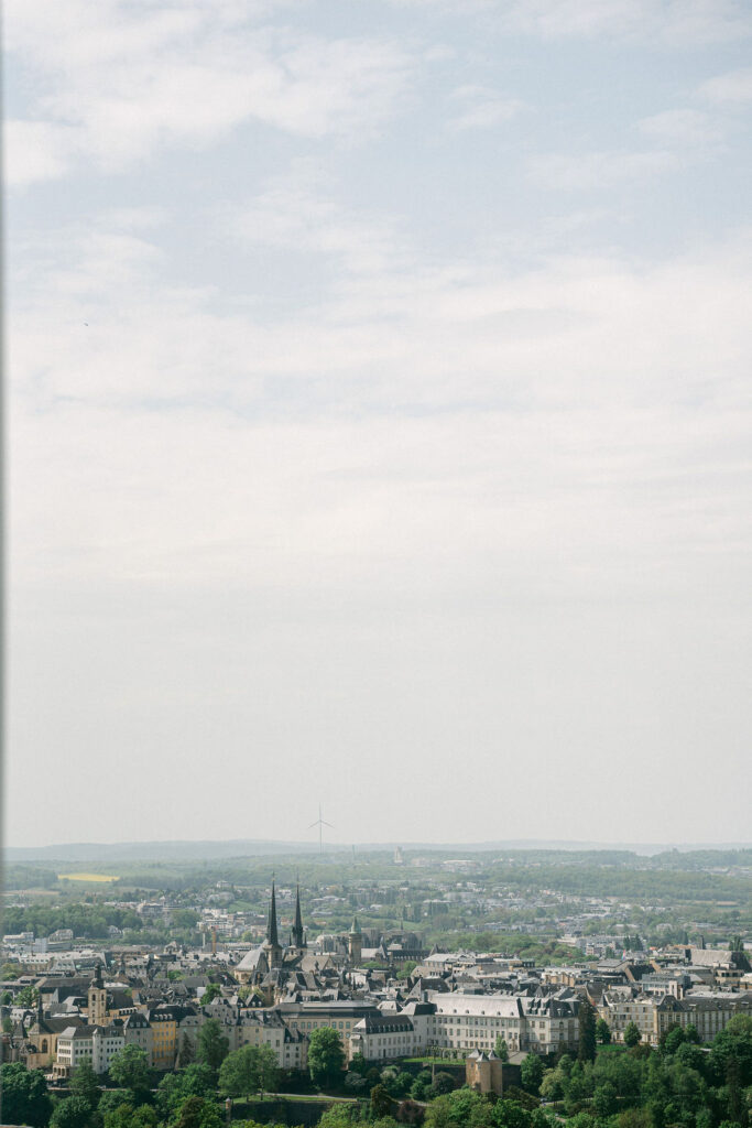 Panoramic view of Luxembourg City skyline with cathedral spires and rolling landscape under an overcast sky