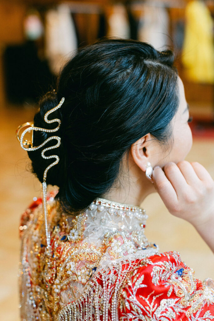 Bride in a traditional red embroidered qipao with an elegant updo adorned by a serpentine gold hair pin at her Luxembourg City wedding