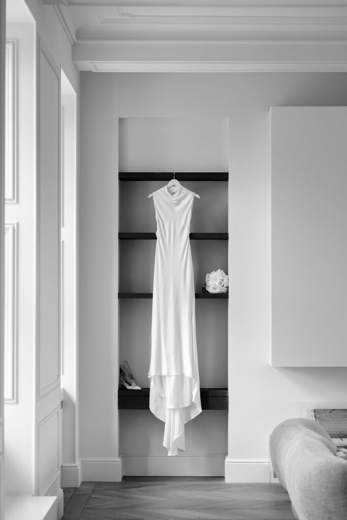 Minimalist bridal gown hanging in a dressing room at Château de Mirwart Belgium wedding morning