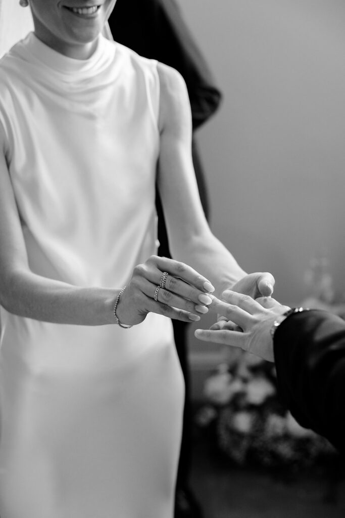 Close up of ring exchange during wedding ceremony at Château de Mirwart Belgium bride Carla and groom Robin black and white