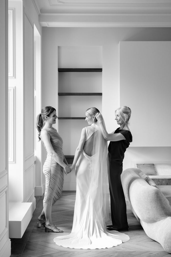 Black and white photo of bride Carla with her bridesmaids getting ready in a bright modern room at Château de Mirwart Belgium