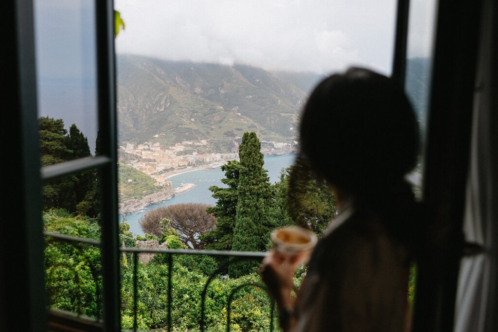 Bride getting ready at Villa Cimbrone on her wedding morning looking out over the Amalfi Coast and the town of Minori below