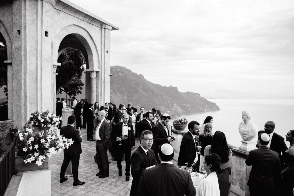 Wedding cocktail hour on the terrace at Villa Cimbrone Ravello with guests mingling overlooking the Amalfi Coast