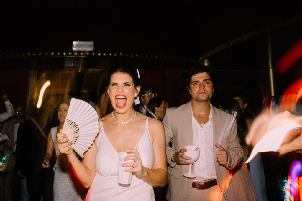 Wedding guests dancing and celebrating with fans and cocktails during the late night party at Château du Bois d'Arlon Belgium