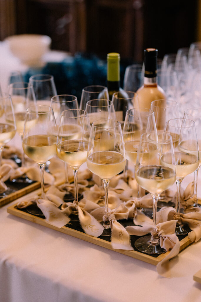 Champagne and white wine glasses on a tray during the wedding cocktail hour at Château du Bois d'Arlon Belgium