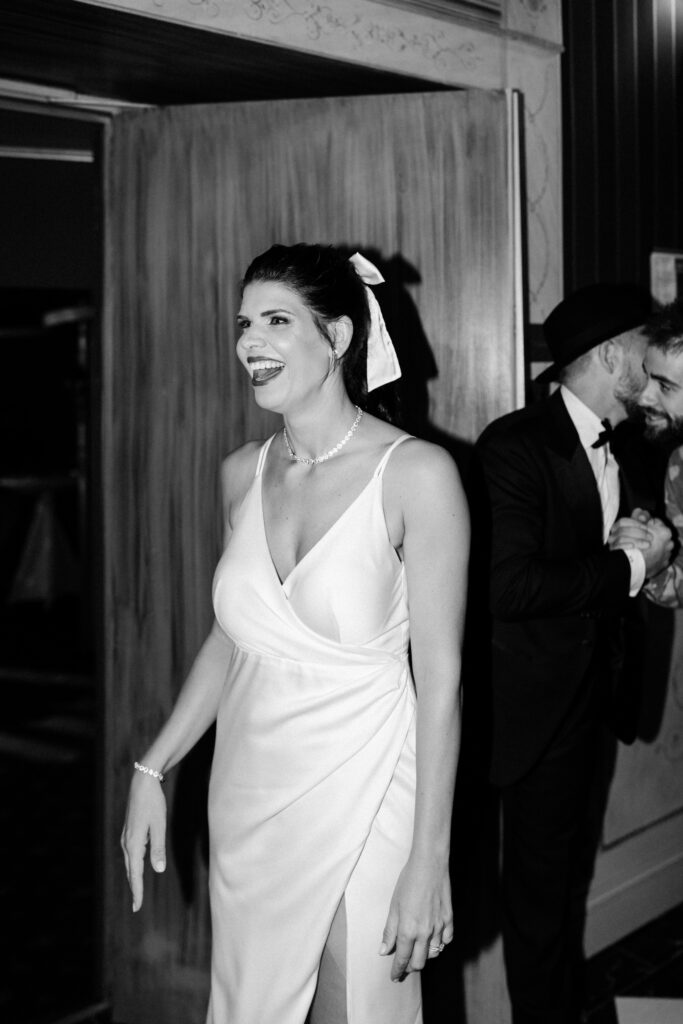 Black and white portrait of bride in her second dress laughing as she enters the wedding party at Château du Bois d'Arlon Belgium