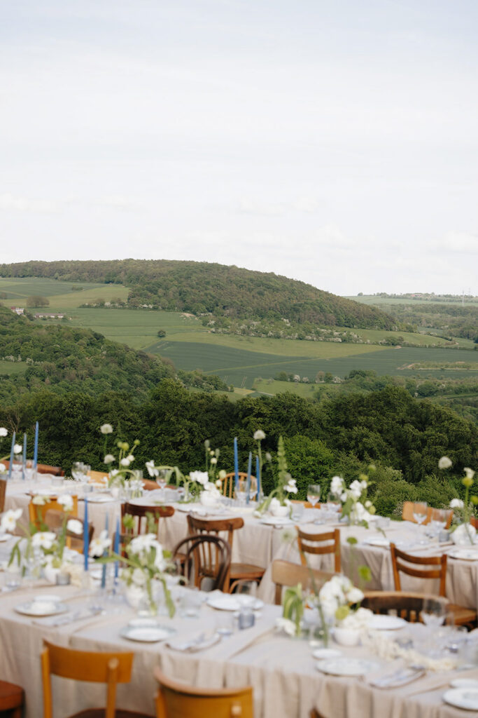Hazelnut House 1851 Luxembourg wedding reception tables set with bentwood chairs and refined florals, overlooking the vineyard hills and open countryside
